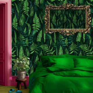 pattern of fern leaves in shades of green shown as wallpaper with green bed