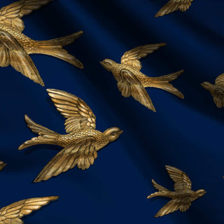 pattern of gold birds on dark blue background shown on fabric