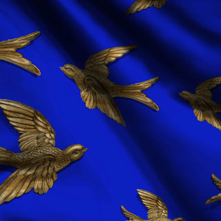 pattern of gold birds on a blue background shown on fabric