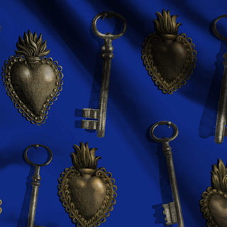 pattern of sacred hearts and keys on royal blue background shown on fabric