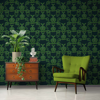 pattern of entwined green snakes on a dark background shown as wallpaper with green chair and sideboard